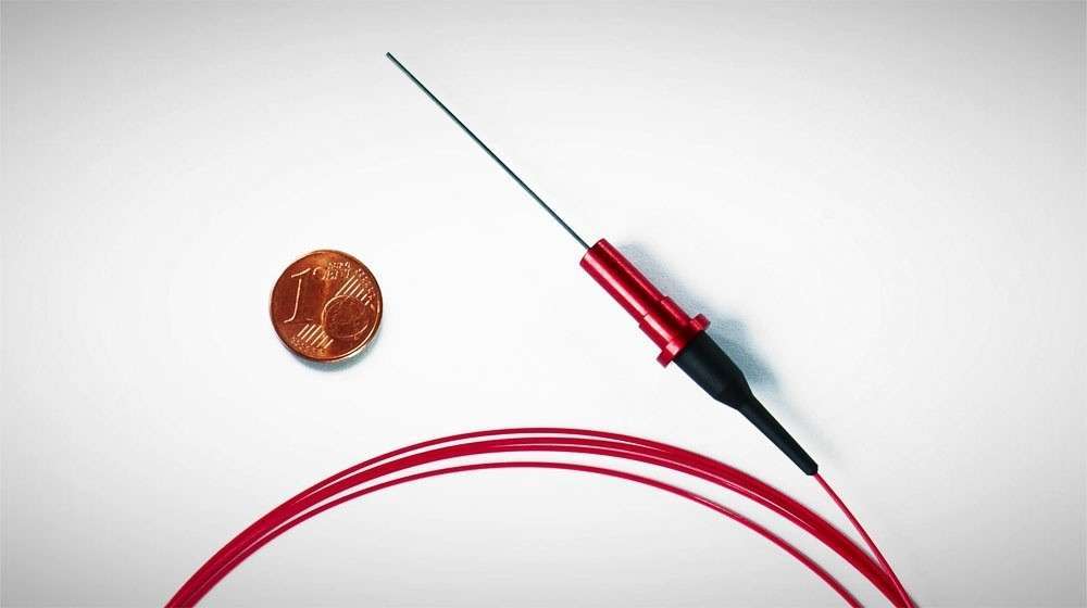 Miniaturized fiber-optic probe compared to one-cent coin
